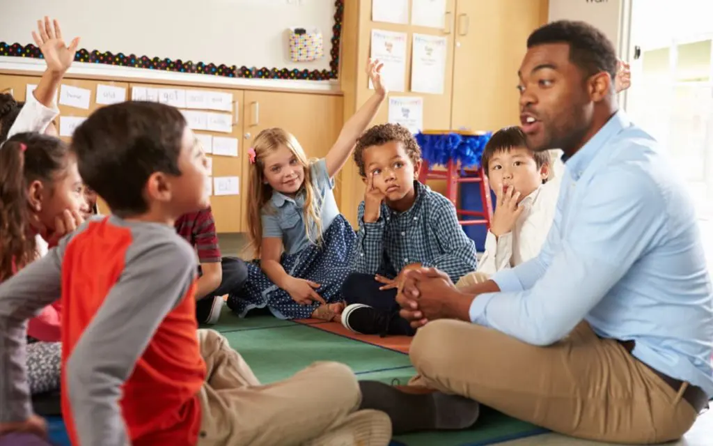 Professional Insurance covers teachers and substitutes like this one sitting on the floor with students
